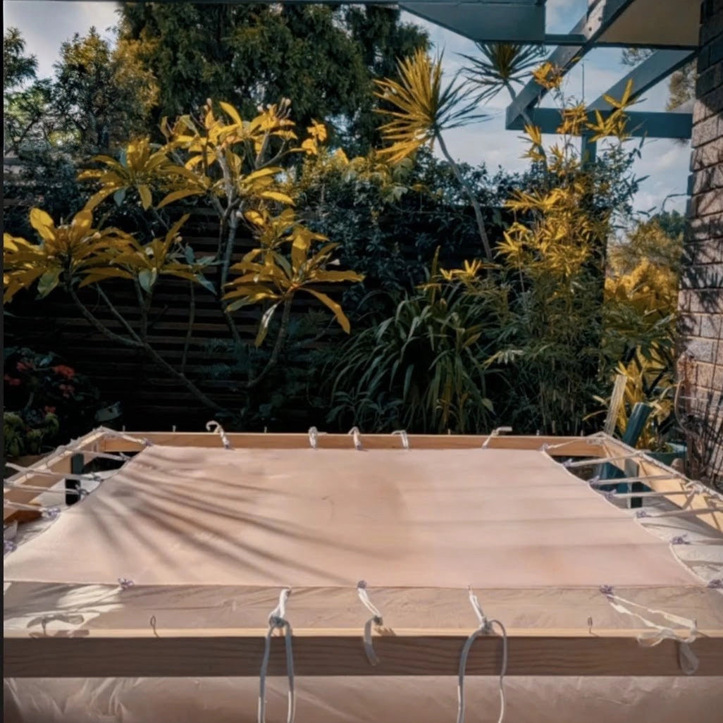 Silk habotai stretched on a timber frame in the B108 studio garden, Sydney, showing the preparation stage before hand-painting.