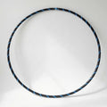 Studio shot of the B108 DESIGN Archival Dance Hoop in Blueberry Bliss featuring a blue and black spiral grip tape pattern against a white backdrop.