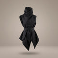 Front view of the Black Denim Kimono Vest floating on a warm grey background, featuring a high sculptural cowl collar, wrapped tied waist sash, and asymmetrical angular hem by B108 DESIGN.