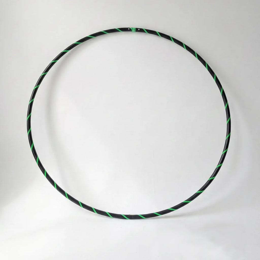 Studio shot of the B108 DESIGN Archival Dance Hoop in Lime Love featuring a fluoro green and black spiral grip tape pattern against a white backdrop.