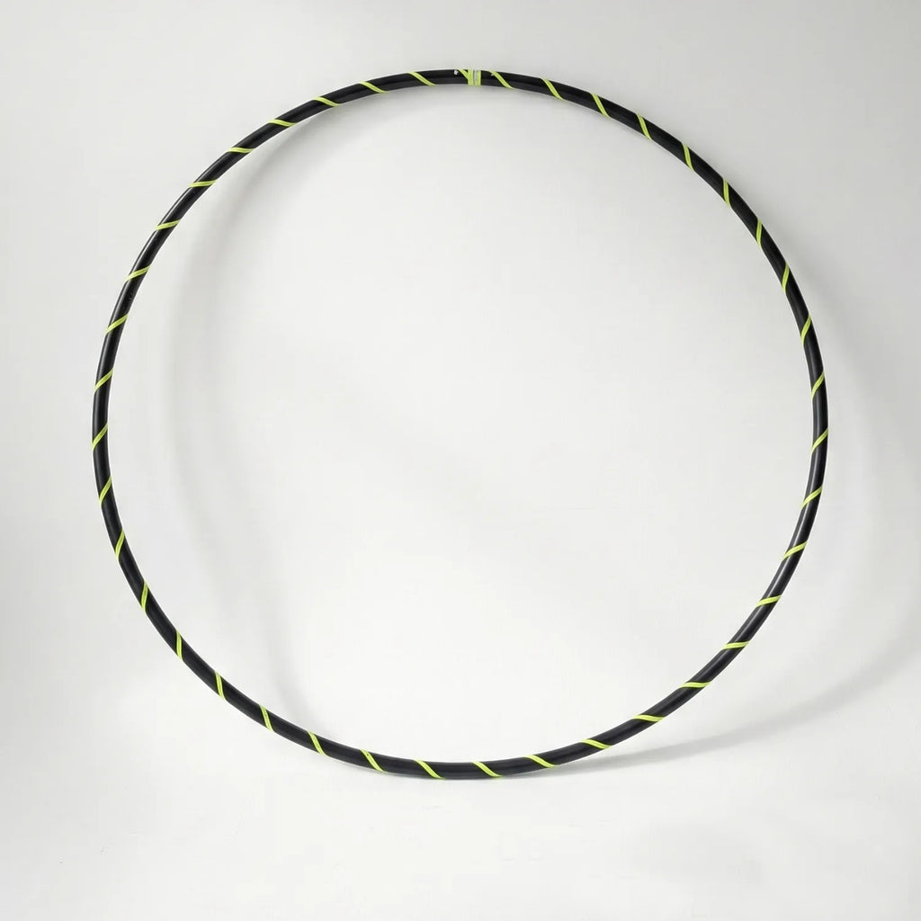 Studio shot of the B108 DESIGN Archival Dance Hoop in Electric Bee featuring a fluoro yellow and black spiral grip tape pattern against a white backdrop. 