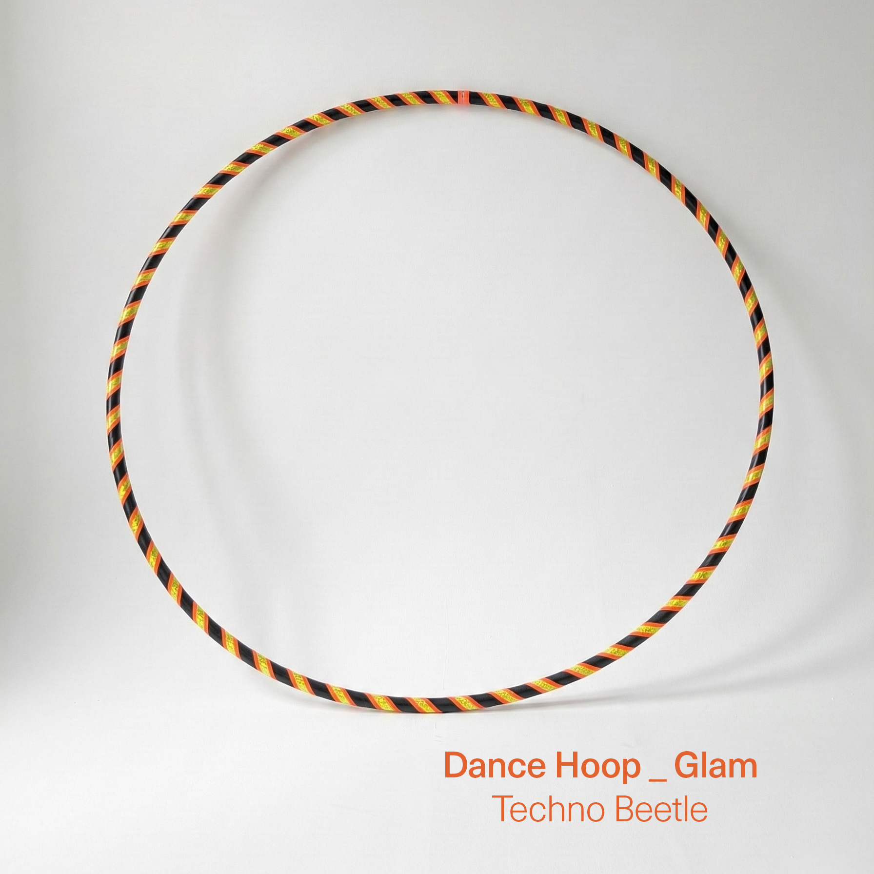 Dance hula hoop ON SALE – Techno Beetle Glam Edition. Professional black tubing featuring a sequin yellow and orange grip tape spiral design for dance and fitness.