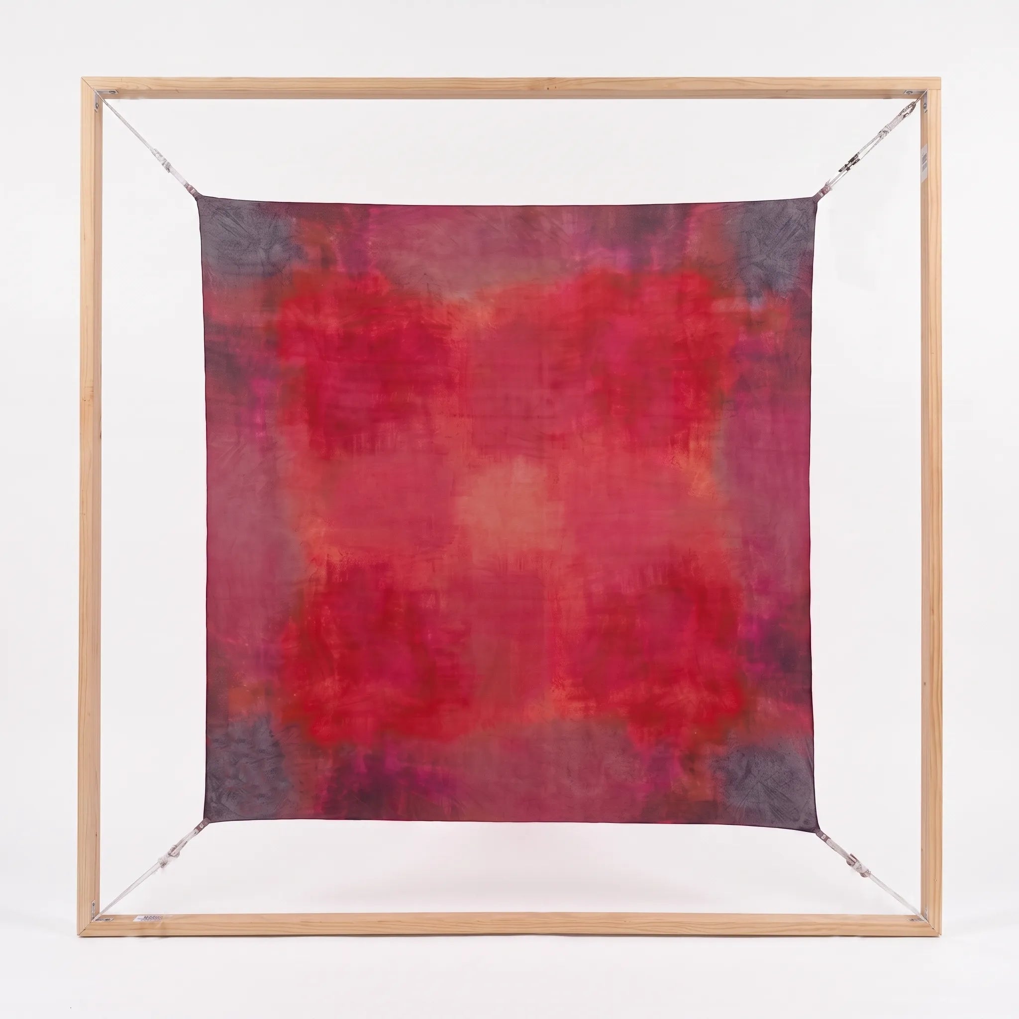 Full view of the square Ember luxury silk Habotai scarf by B108 Design displayed flat within a square wooden frame, showing the hand-dyed crimson, magenta, and plum gradient pattern.