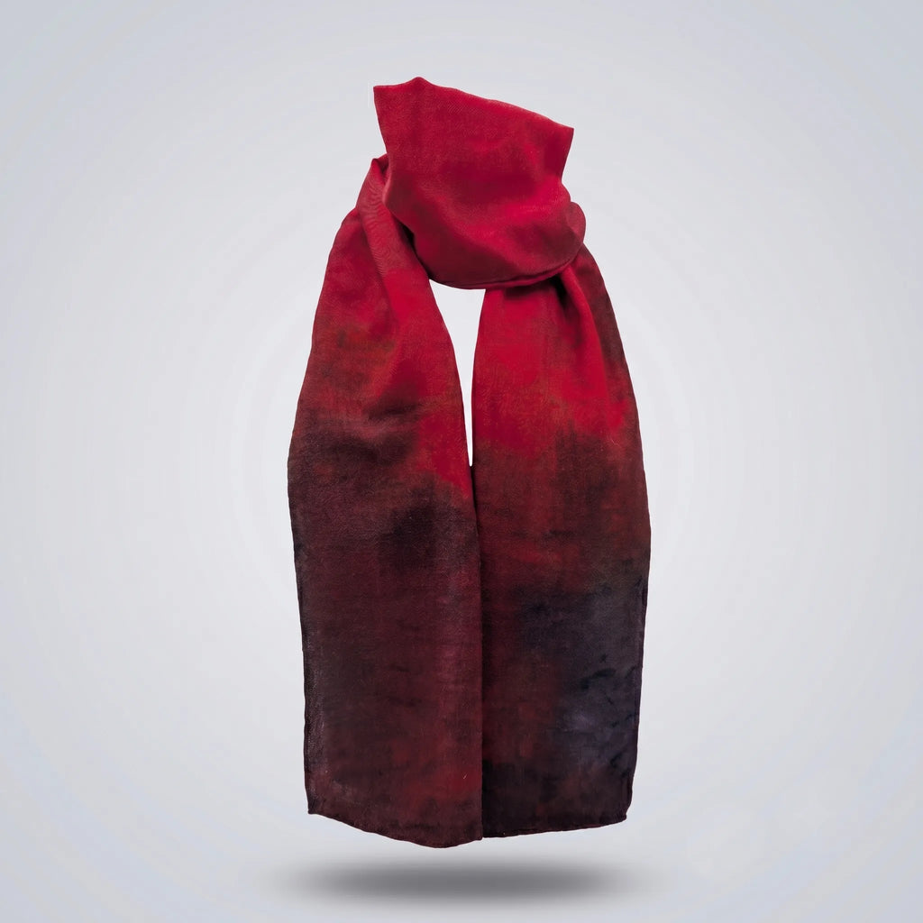 Front view of the Ember luxury silk-wool scarf by B108 Design draped in a loose knot, featuring a rich crimson red gradient shading into deep charcoal and dark burgundy tones.