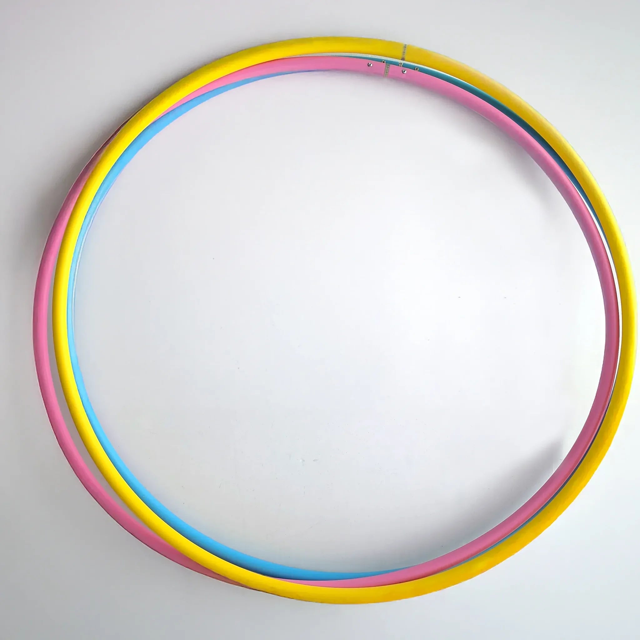 Set of three B108 DESIGN kids dance hula hoops in bright blue, pink, and yellow stacked together against a clean white background.