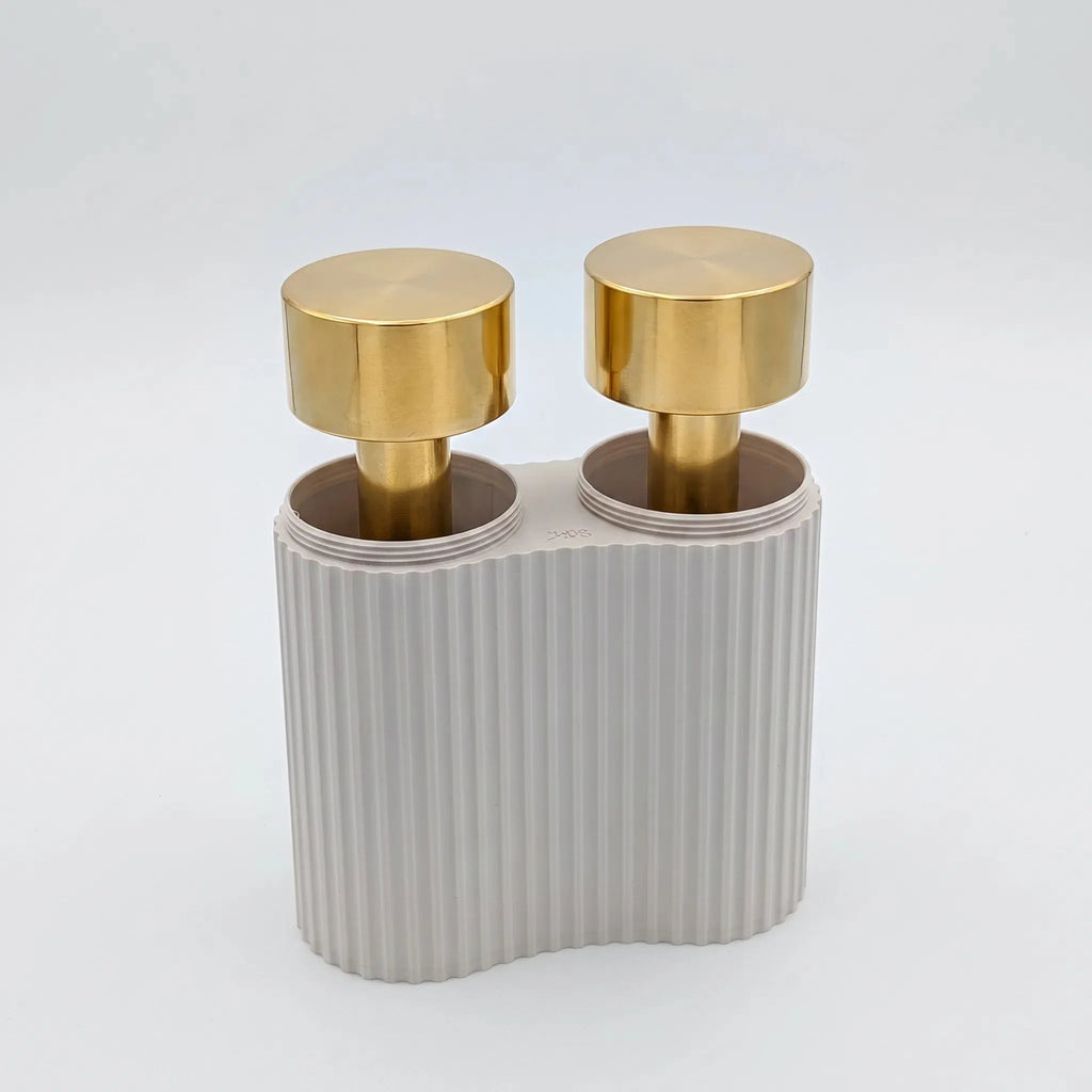 Pair of solid brass hand weights by B108 Design resting upright inside their custom off-white ribbed pillar storage case against a white background.