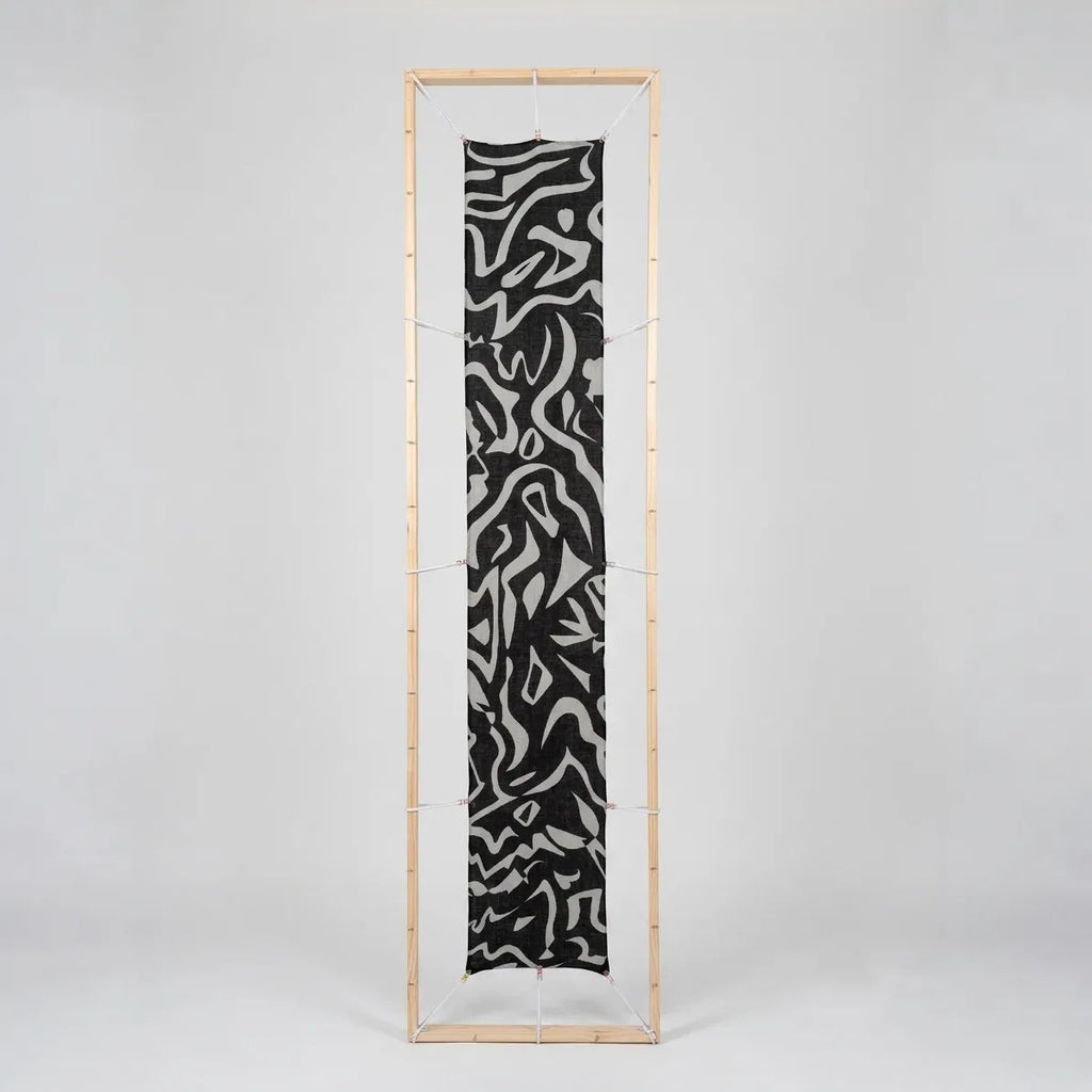 B108 Tectonica Wool-Silk Scarf in Monochrome stretched flat inside a wooden studio display frame.
