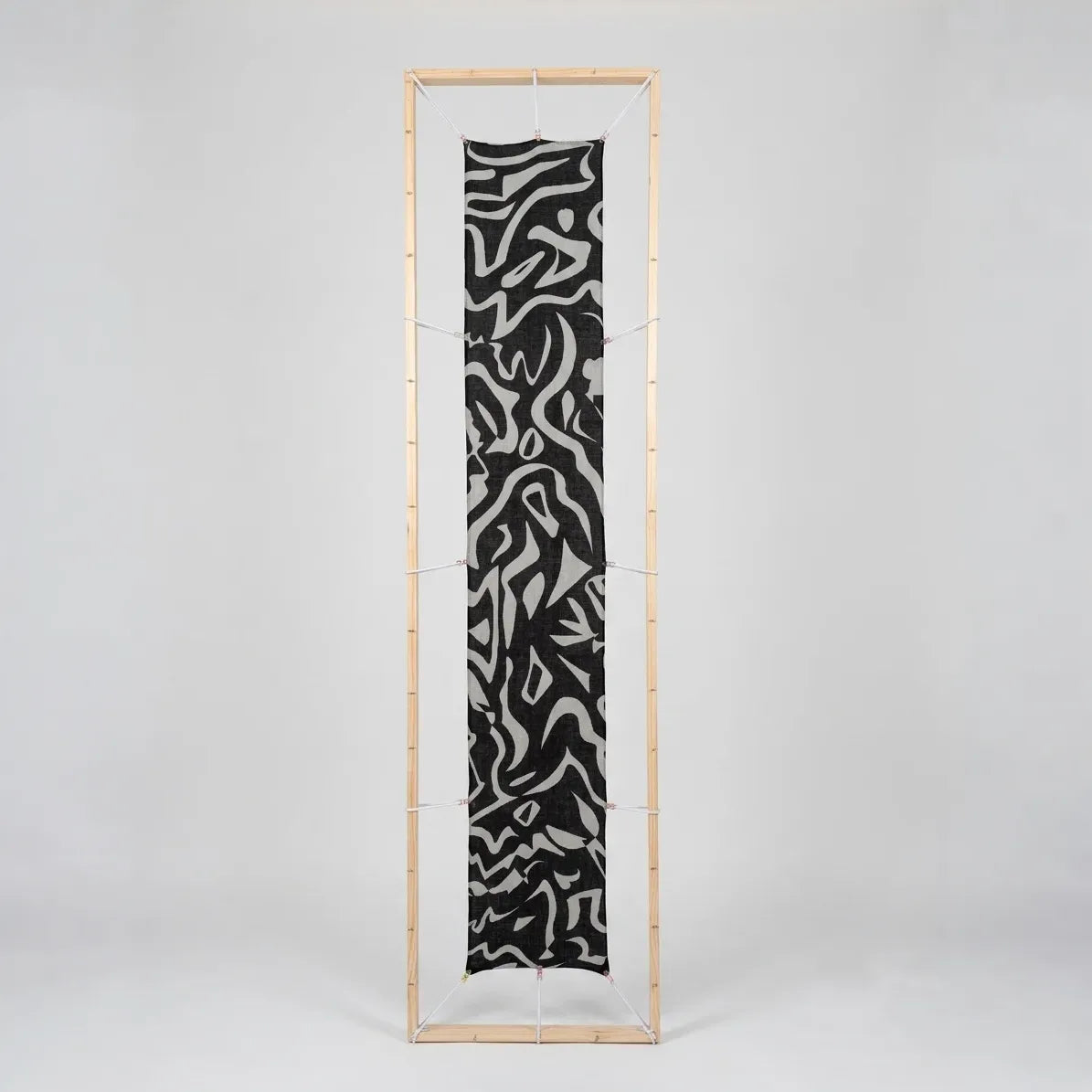 B108 Tectonica Wool-Silk Scarf in Monochrome stretched flat inside a wooden studio display frame.