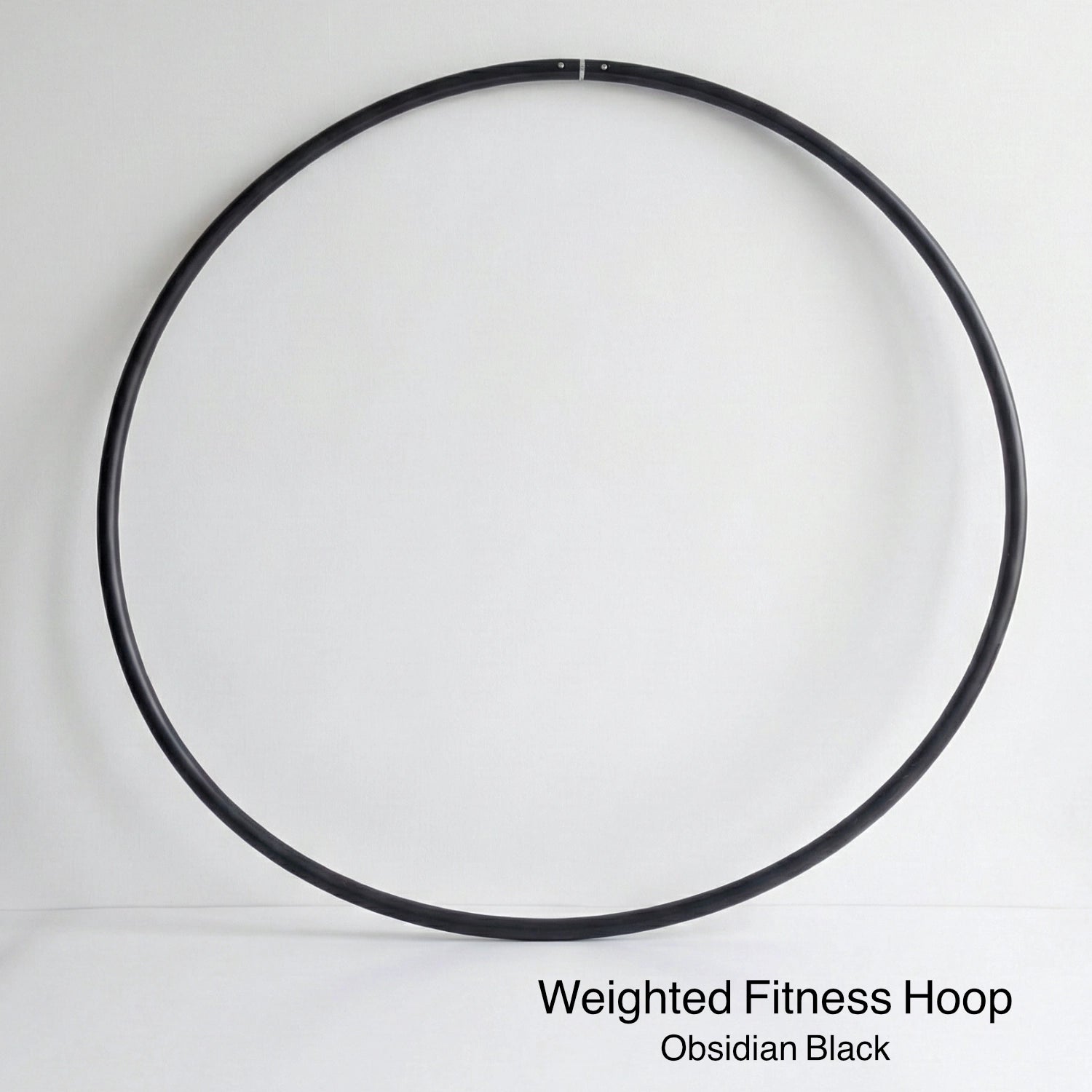 Weighted fitness hula hoop for adults in Obsidian Black, featuring untaped natural grip tubing for professional core workouts.